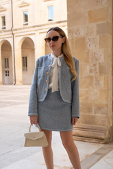 a lady in a white shirt and a blue two piece skirt set